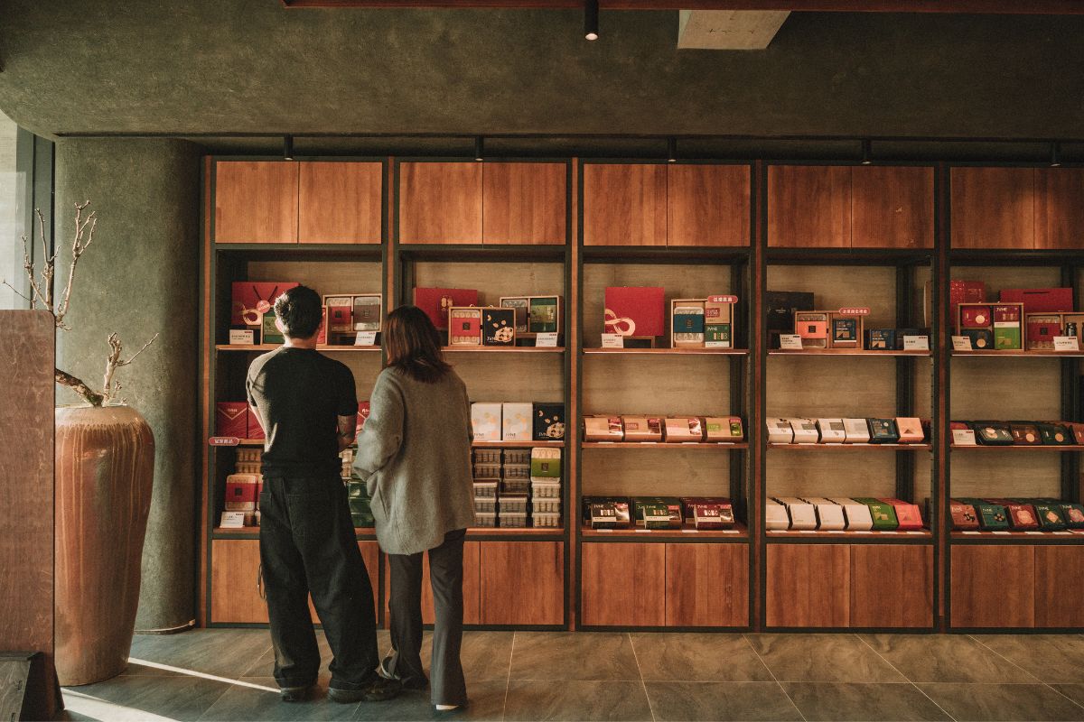 六月初一永春觀光旗艦店展售區全景，木質貨架陳列8結蛋捲與精美禮盒