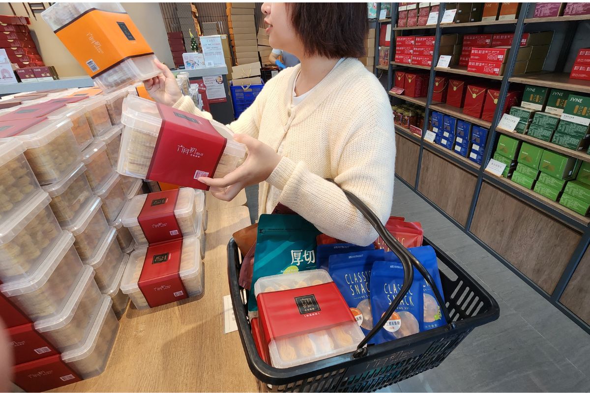 台中美村門市客人選購伴手禮情境，在地人買蛋捲禮盒零食的第一站